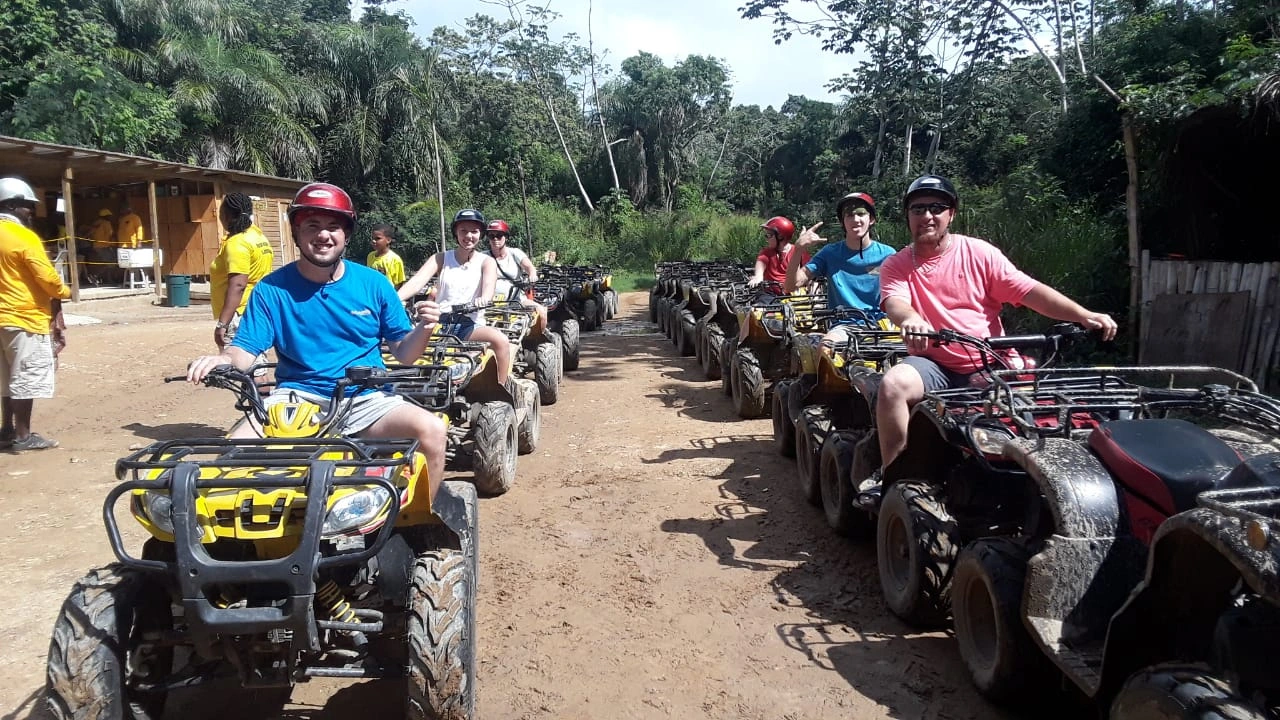 Guests riding ATVs on a jungle trail